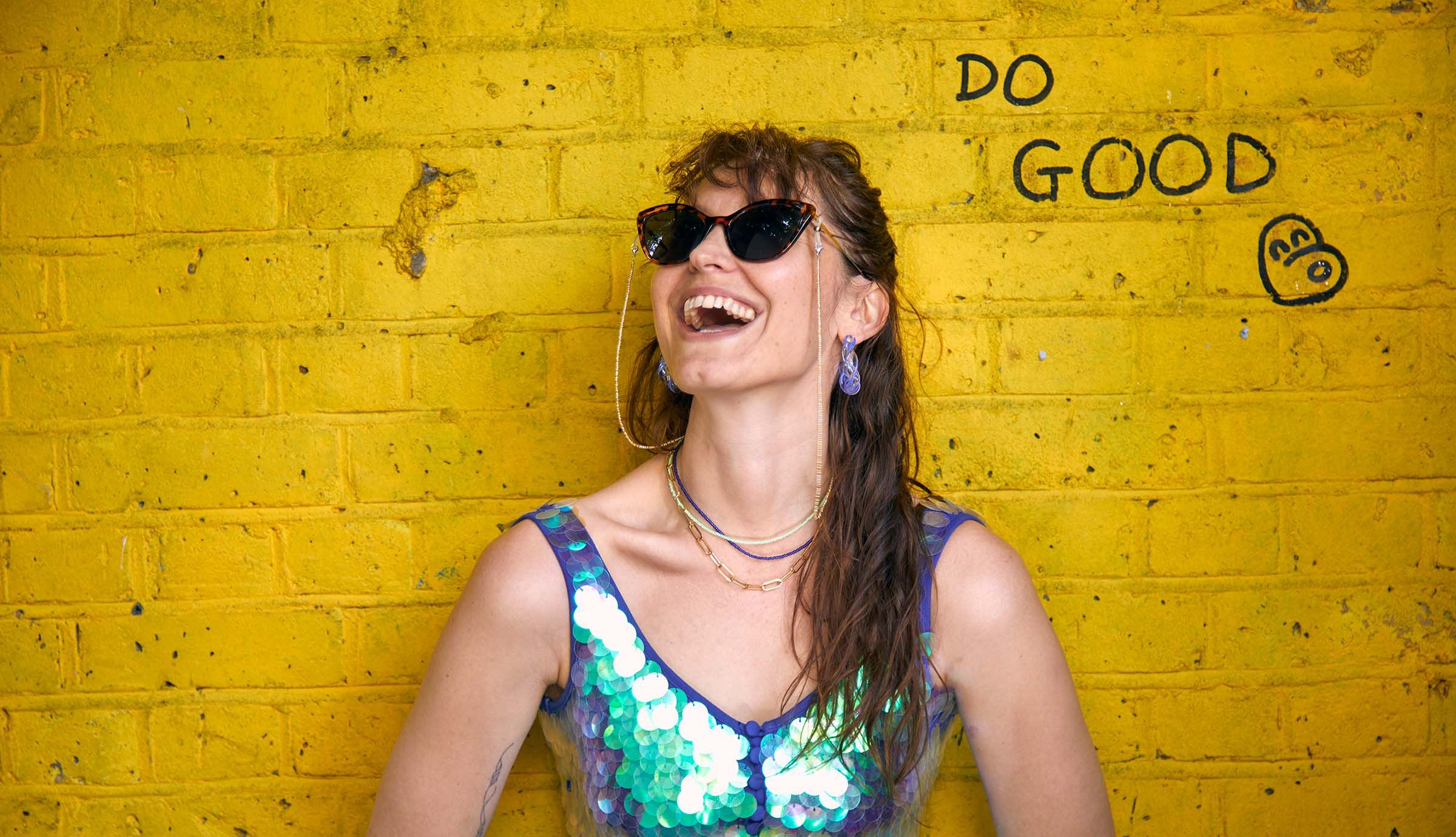 Model is wearing gold bead glasses chain, gold paperclip necklace, luna navy and limeade bead necklaces