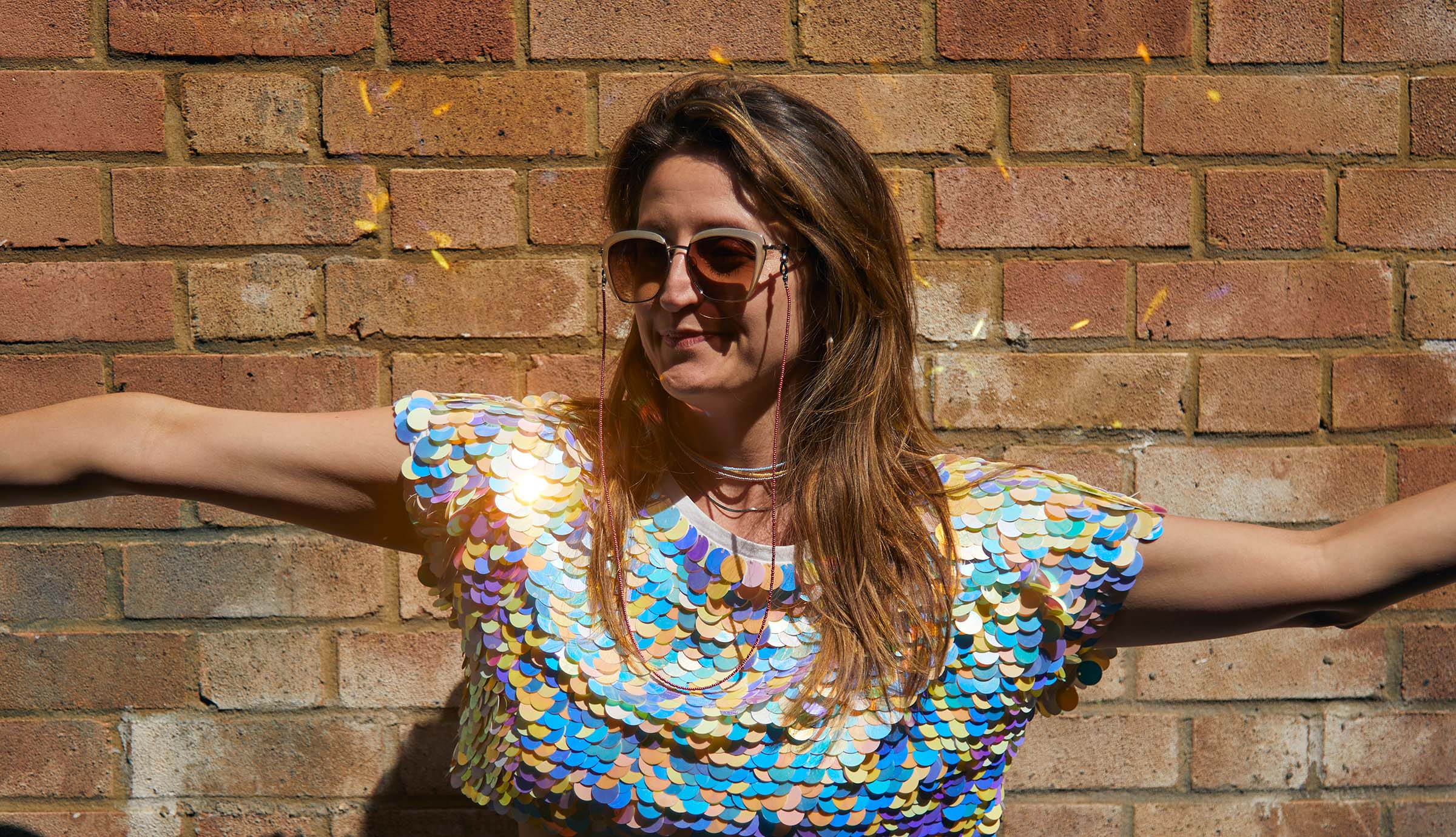 Model is wearing luna ocean blue, sun glow yellow neon, and silver bead necklaces and silver snake chain necklace with celeste light cranberry glasses chain